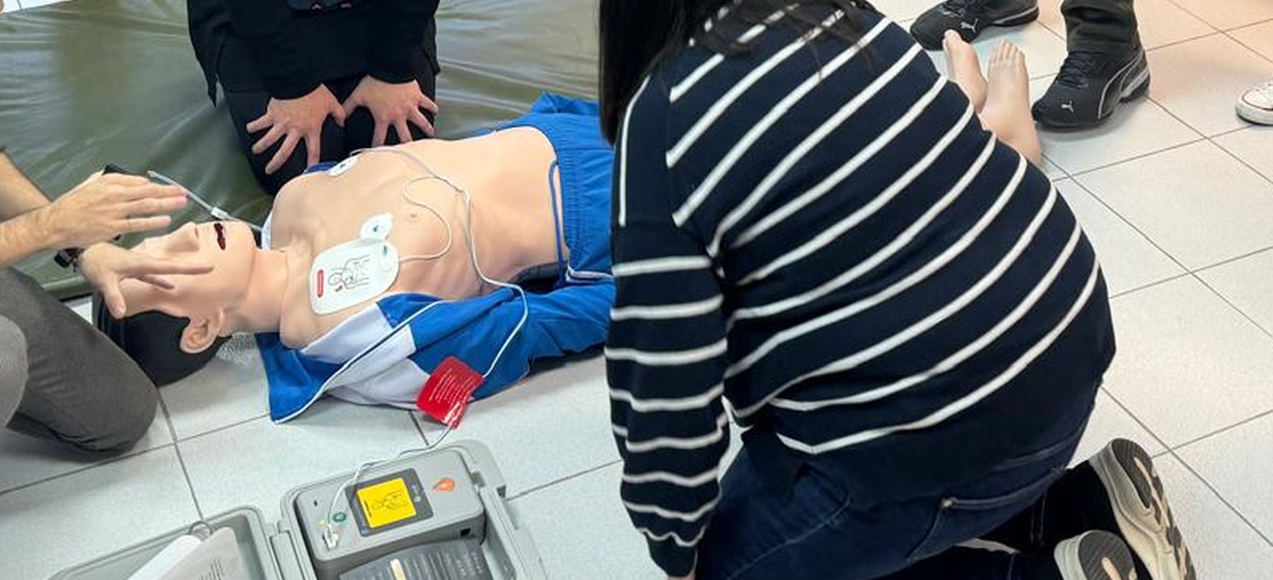 Participantes practicando reanimación y uso de un desfibrilador de entrenamiento